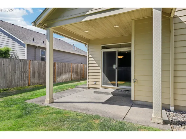 a view of backyard with door and wooden fence