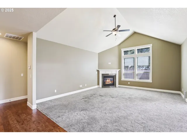 a view of an empty room with window and fireplace