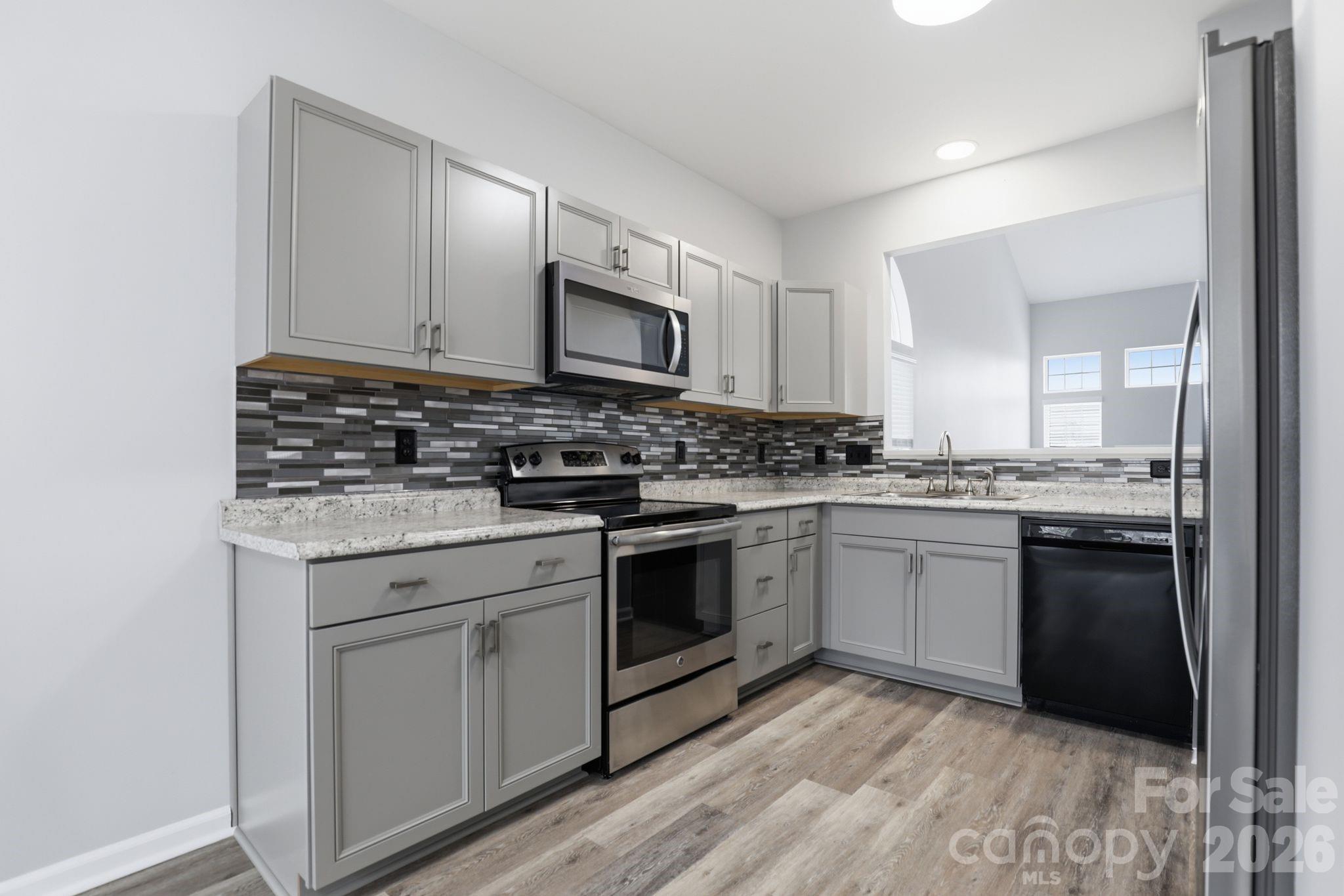 7978 Mariners Pointe Circle Denver, NC 28037 - Photo 2 of 37 a kitchen with stainless steel appliances granite countertop a stove a sink and a microwave