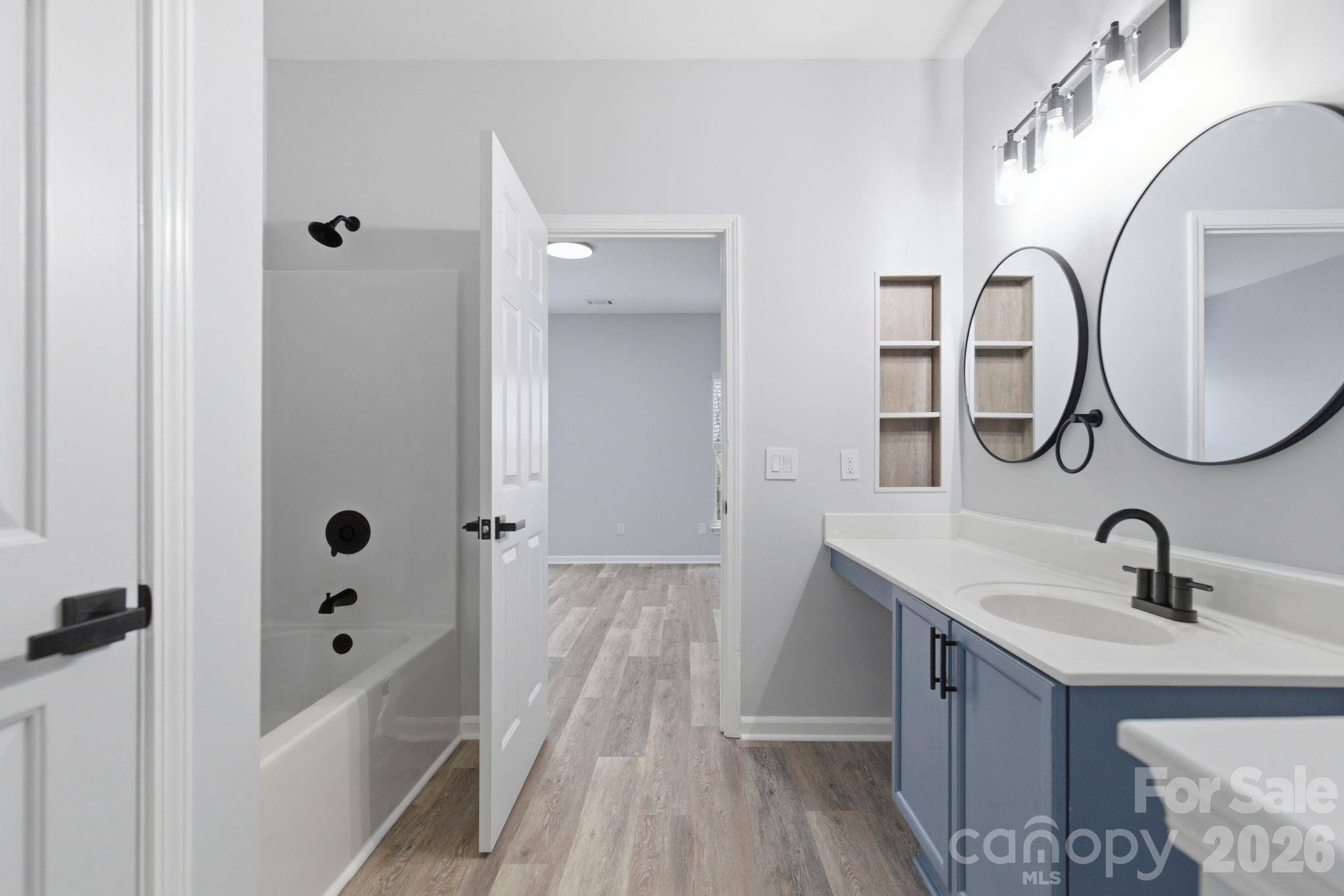 7978 Mariners Pointe Circle Denver, NC 28037 - Photo 4 of 37 a bathroom with a sink and mirror with bathtub