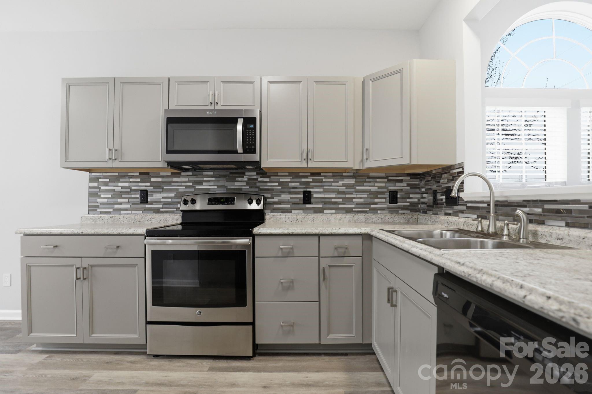 7978 Mariners Pointe Circle Denver, NC 28037 - Photo 8 of 37 a kitchen with stainless steel appliances granite countertop a sink stove a microwave and cabinets