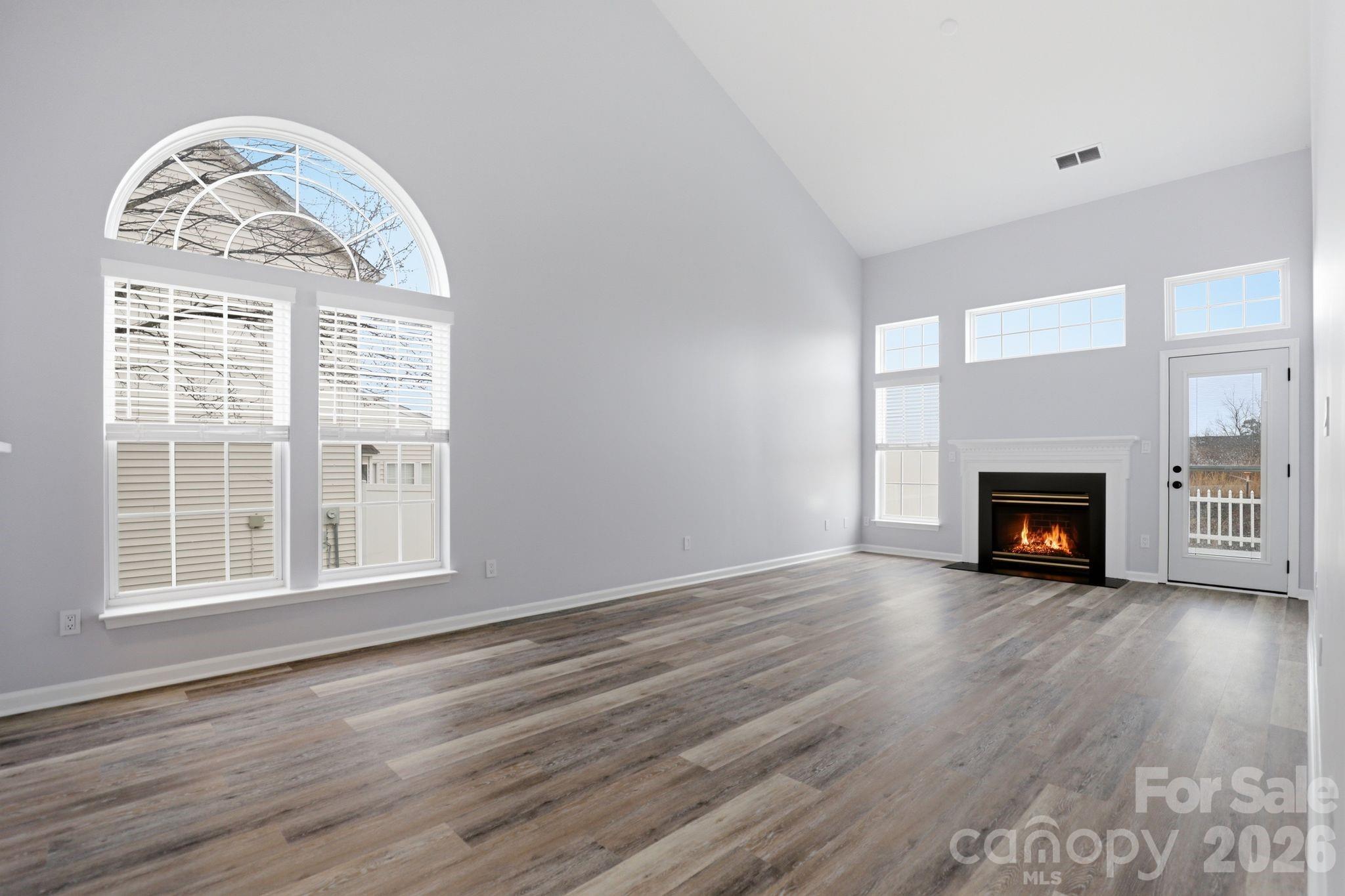 7978 Mariners Pointe Circle Denver, NC 28037 - Photo 10 of 37 an empty room with wooden floor fireplace and windows