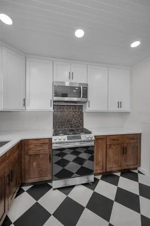 a kitchen with granite countertop stainless steel appliances a sink and cabinets