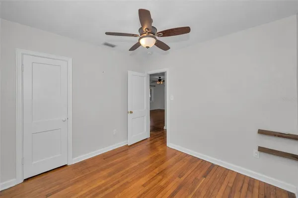 a view of empty room with wooden floor