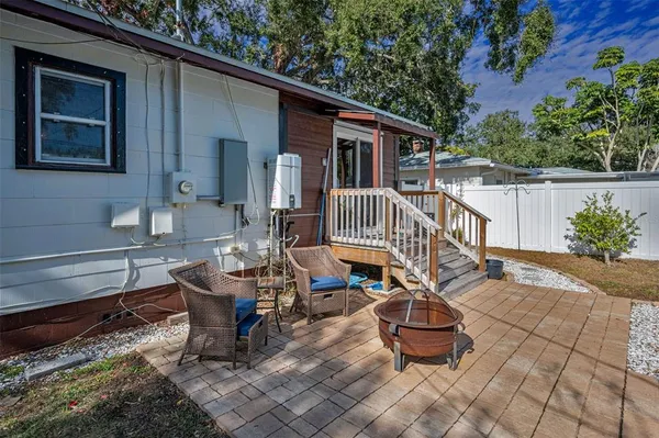 a roof deck with table and chairs and potted plants