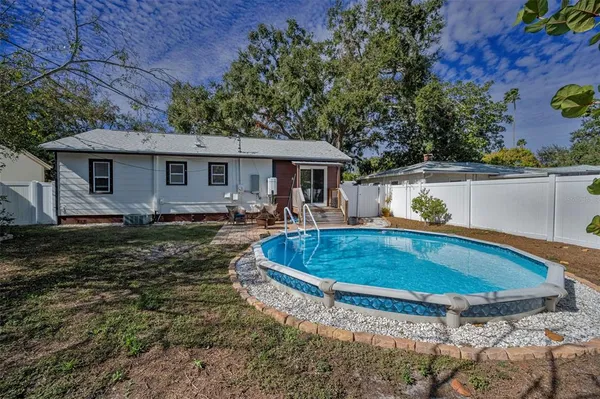 a view of a house with pool yard and sitting area