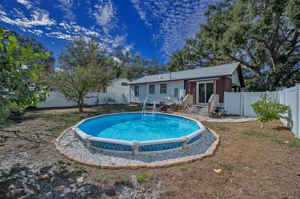 a view of a house with backyard and trees