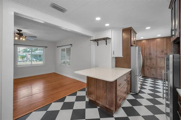 a kitchen with a checkered floor and white cabinets