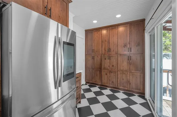 a view of a refrigerator in kitchen and a window