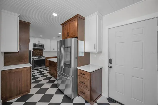 a kitchen with stainless steel appliances granite countertop a refrigerator and a sink