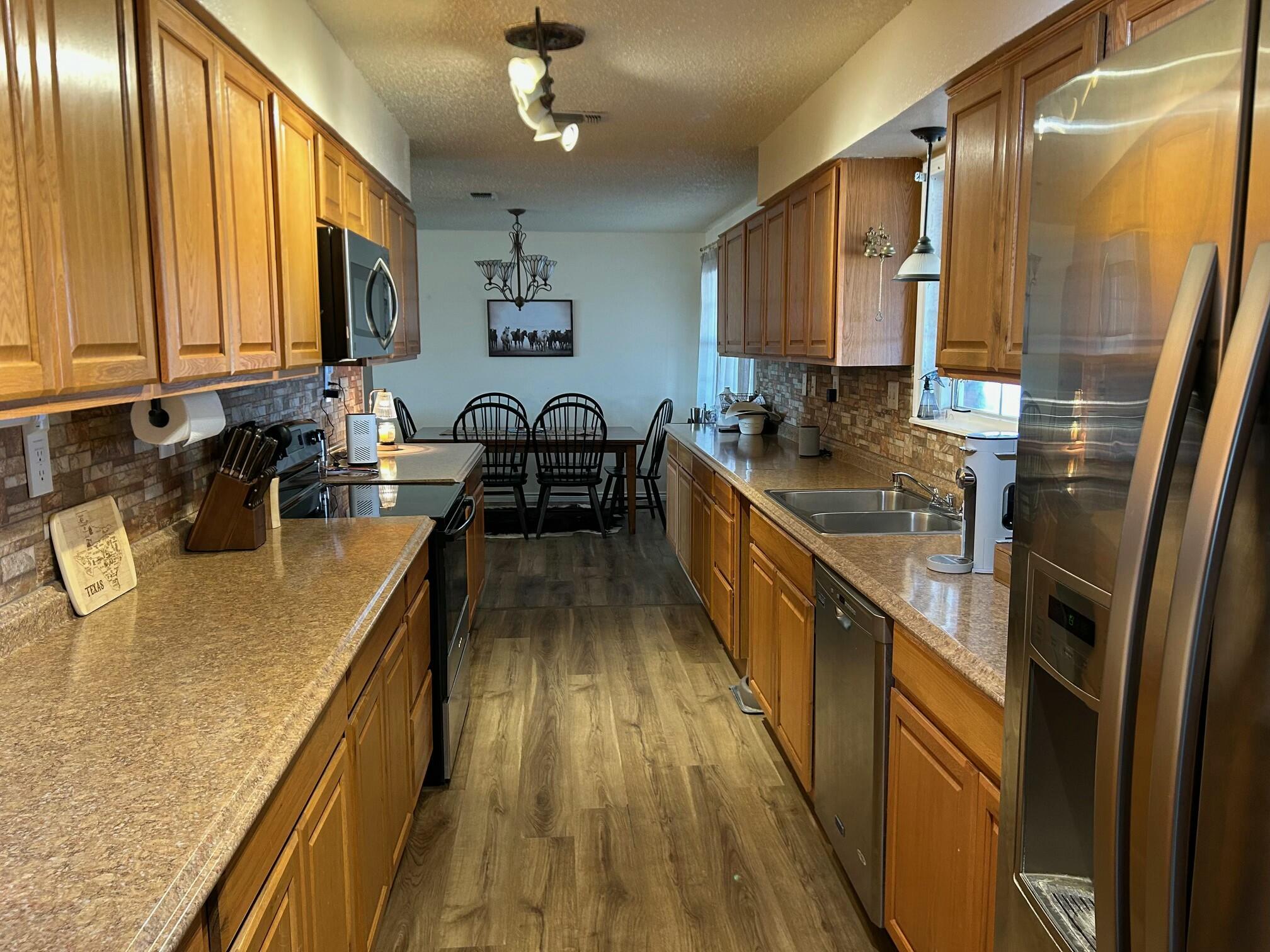 3006 County Road 3500 Lubbock, TX 79403 - Photo 8 of 23 a kitchen with stainless steel appliances granite countertop sink stove refrigerator and cabinets