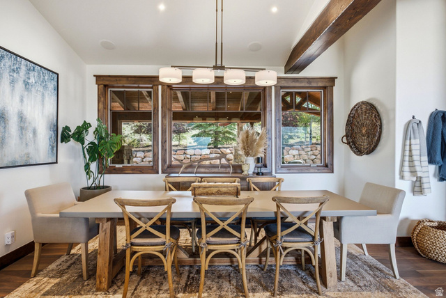 7885 North Rabbitbrush Court, Unit 13 Park City, UT 84098 - Photo 18 of 88 Dining area featuring a linear chandelier with four drum shades, three framed windows with wood trim, and a wood-finish floor