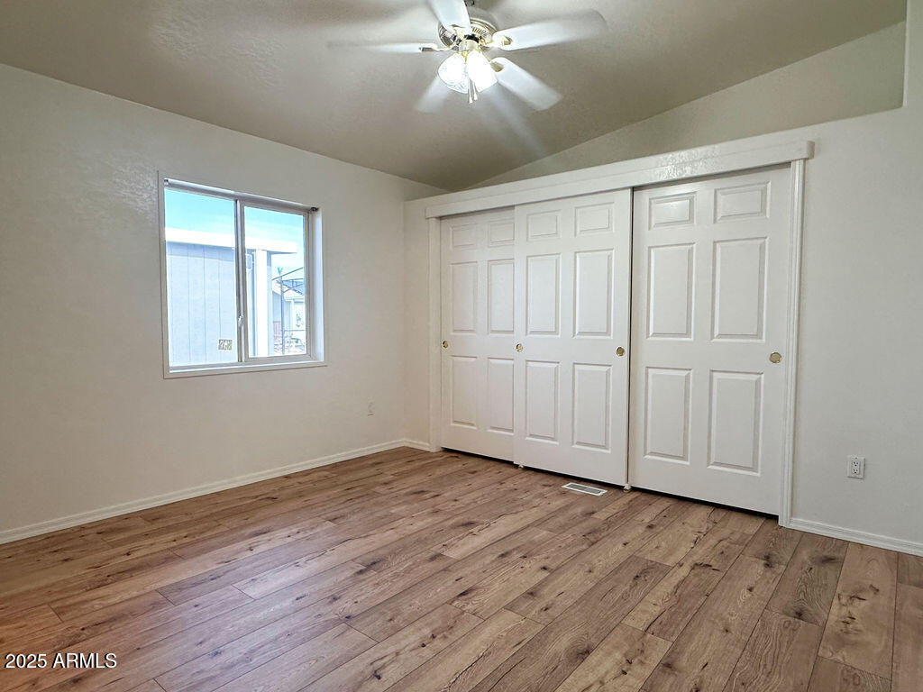 2054 North Thornton Road, Unit 187 Casa Grande, AZ 85122 - Photo 13 of 14 a view of an empty room with wooden floor and a window