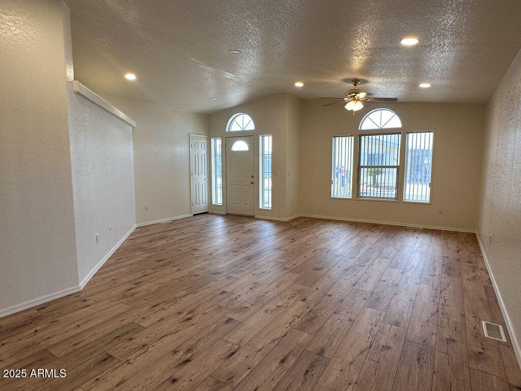 2054 North Thornton Road, Unit 187 Casa Grande, AZ 85122 - Photo 3 of 14 an empty room with wooden floor and windows