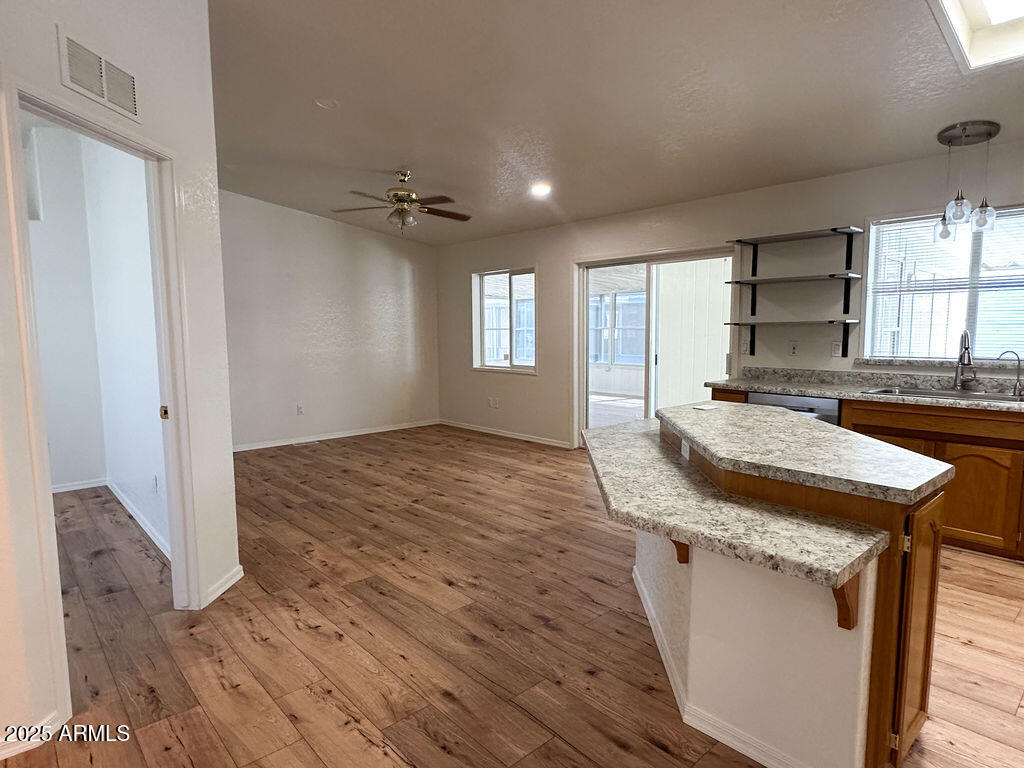 2054 North Thornton Road, Unit 187 Casa Grande, AZ 85122 - Photo 5 of 14 an empty room with wooden floor and windows