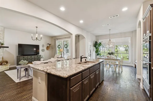 a open kitchen with a sink a counter top space and living room view