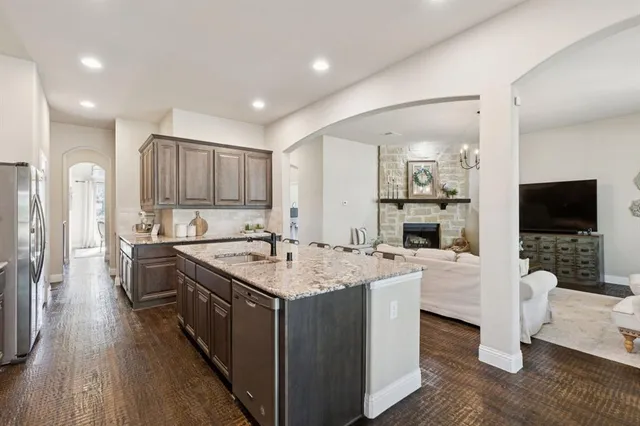 a large kitchen with stainless steel appliances granite countertop a lot of counter space and wooden floor
