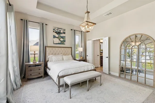 a bedroom with a large bed and a chandelier