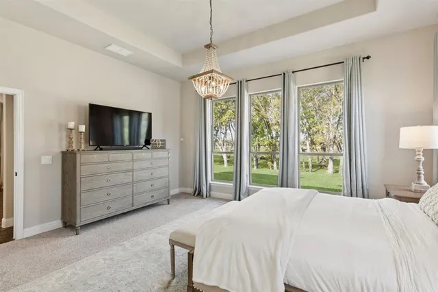 a bedroom with a bed and a flat tv screen on dresser