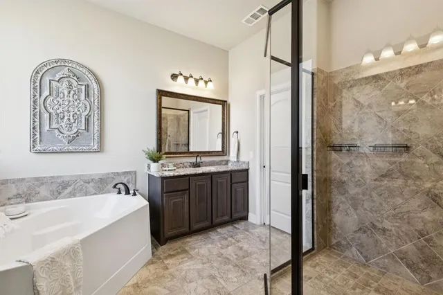 a spacious bathroom with a tub sink and mirror