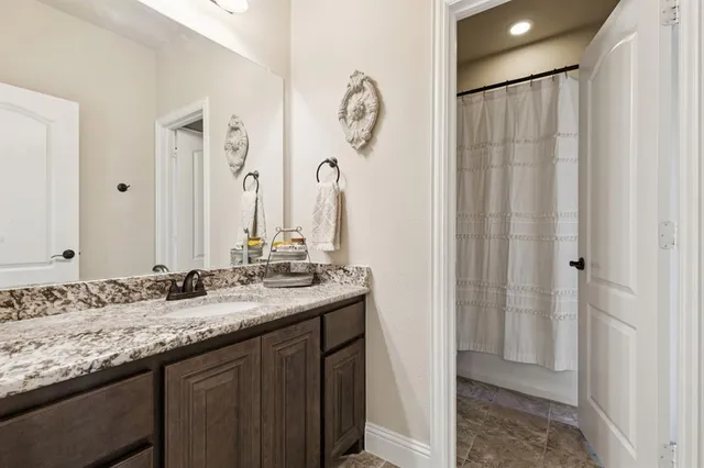 a bathroom with a granite countertop sink and a mirror