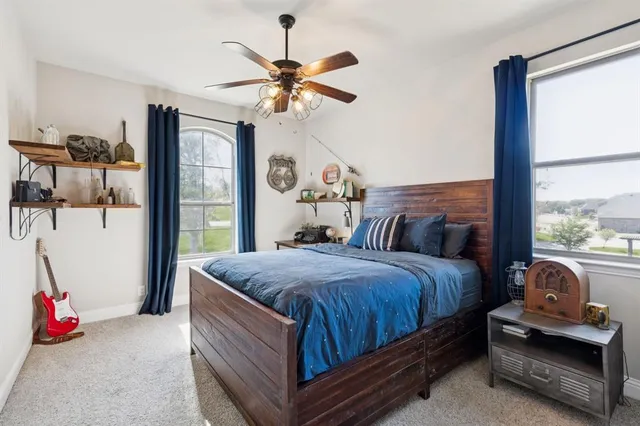 a bed sitting in a bedroom next to a window