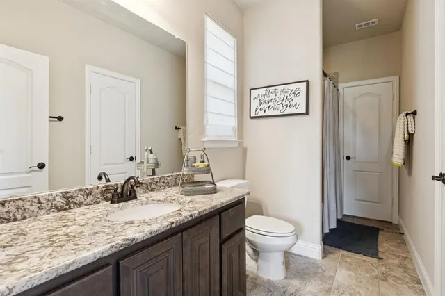 a bathroom with a granite countertop sink toilet a large mirror a vanity and shower