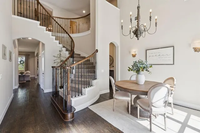a view of a dining room with wooden floor and a chandelier
