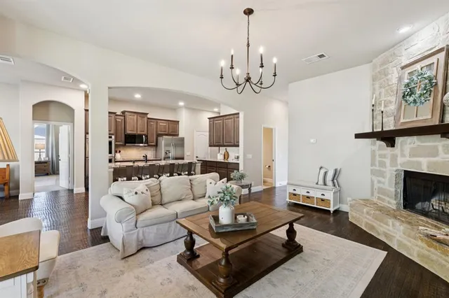 a living room with furniture a fireplace and a chandelier