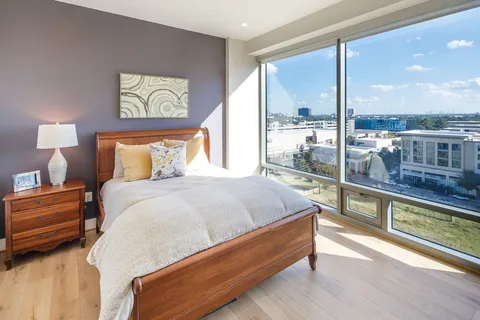 a bed sitting in a bedroom next to a large window