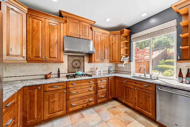 a kitchen with stainless steel appliances granite countertop a sink and cabinets