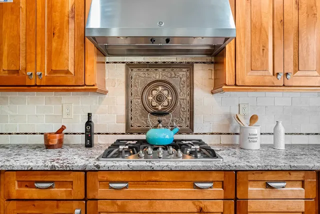 a kitchen with granite countertop a sink a stove and cabinets