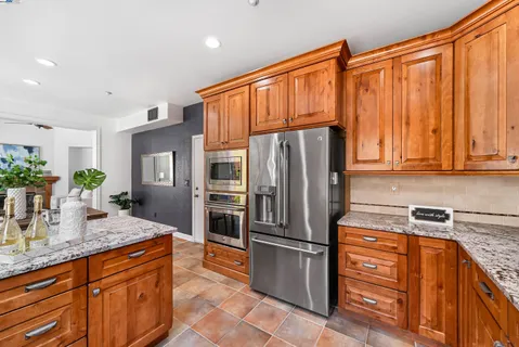 a kitchen with stainless steel appliances granite countertop a refrigerator and a sink