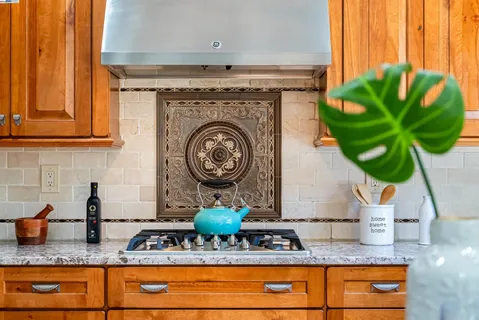 a kitchen with granite countertop a sink a stove and a wooden floor