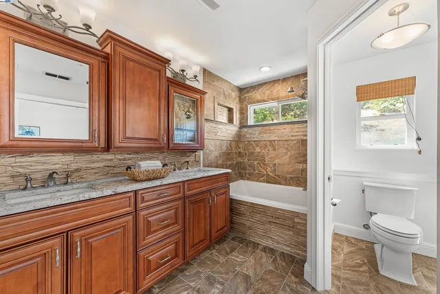 a bathroom with a granite countertop sink toilet and shower