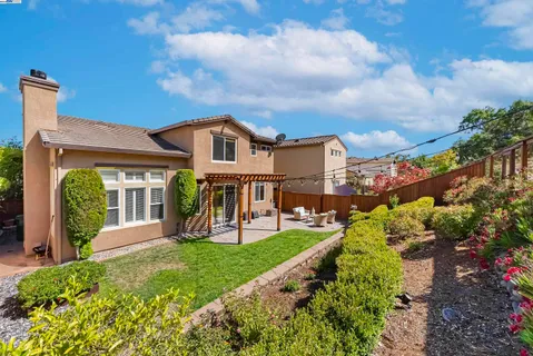 a view of a house with a yard and potted plants