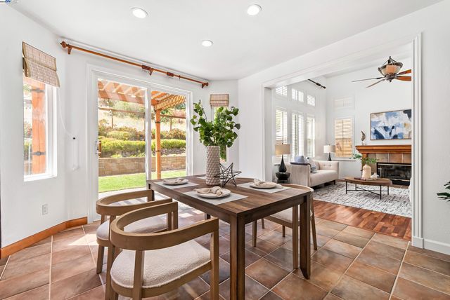 a living room with furniture a dining table and a large window