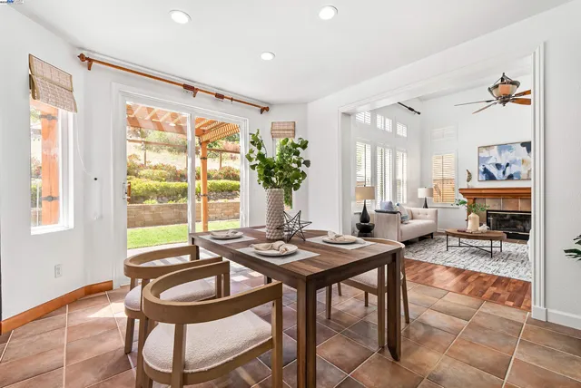 a living room with furniture a dining table and a large window