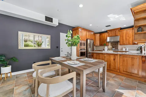 a kitchen with a table chairs sink and cabinets