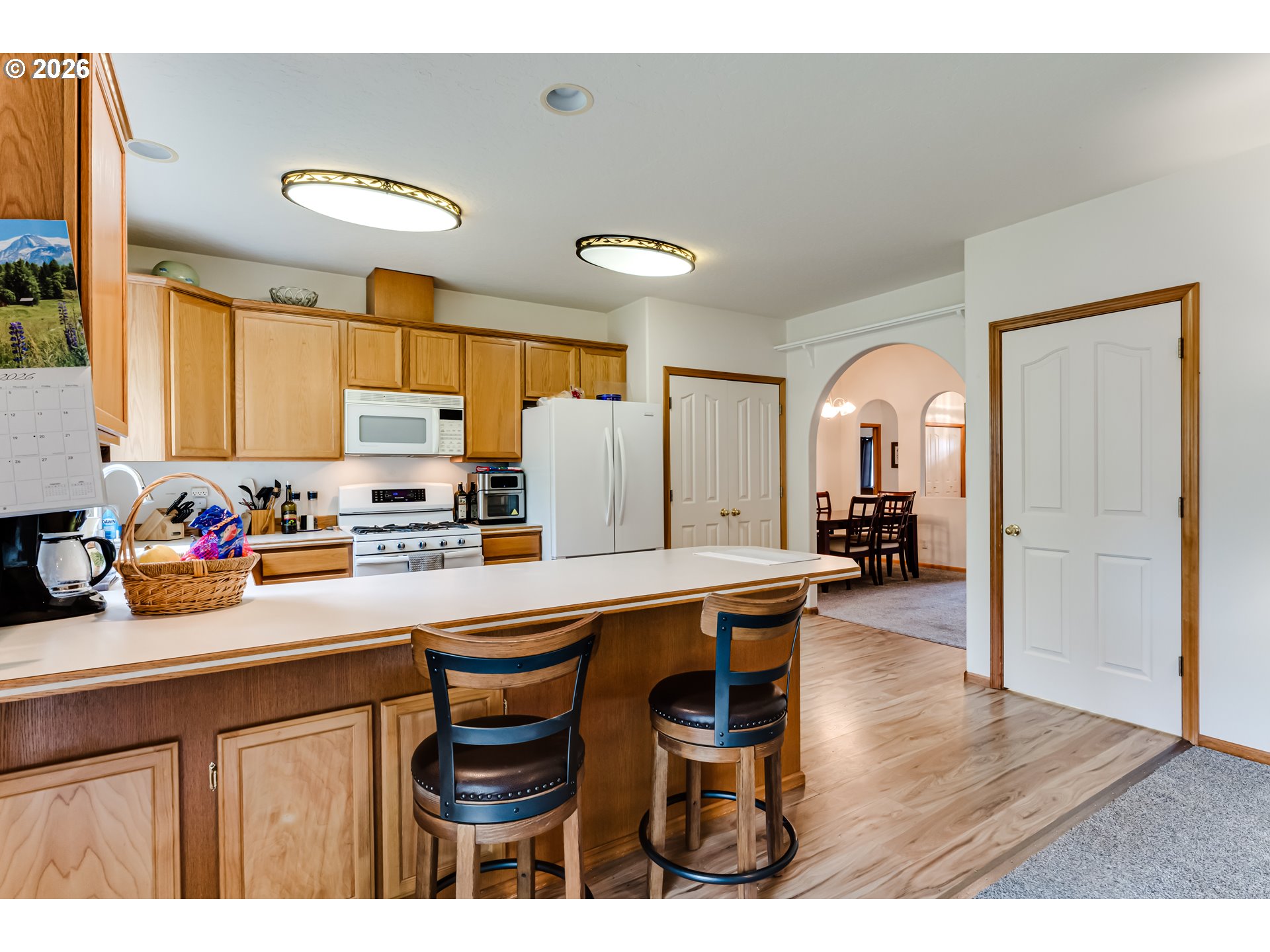 3513 Kendra Street Eugene, OR 97404 - Photo 19 of 45 a kitchen with stainless steel appliances a sink a stove a refrigerator cabinets and living room view