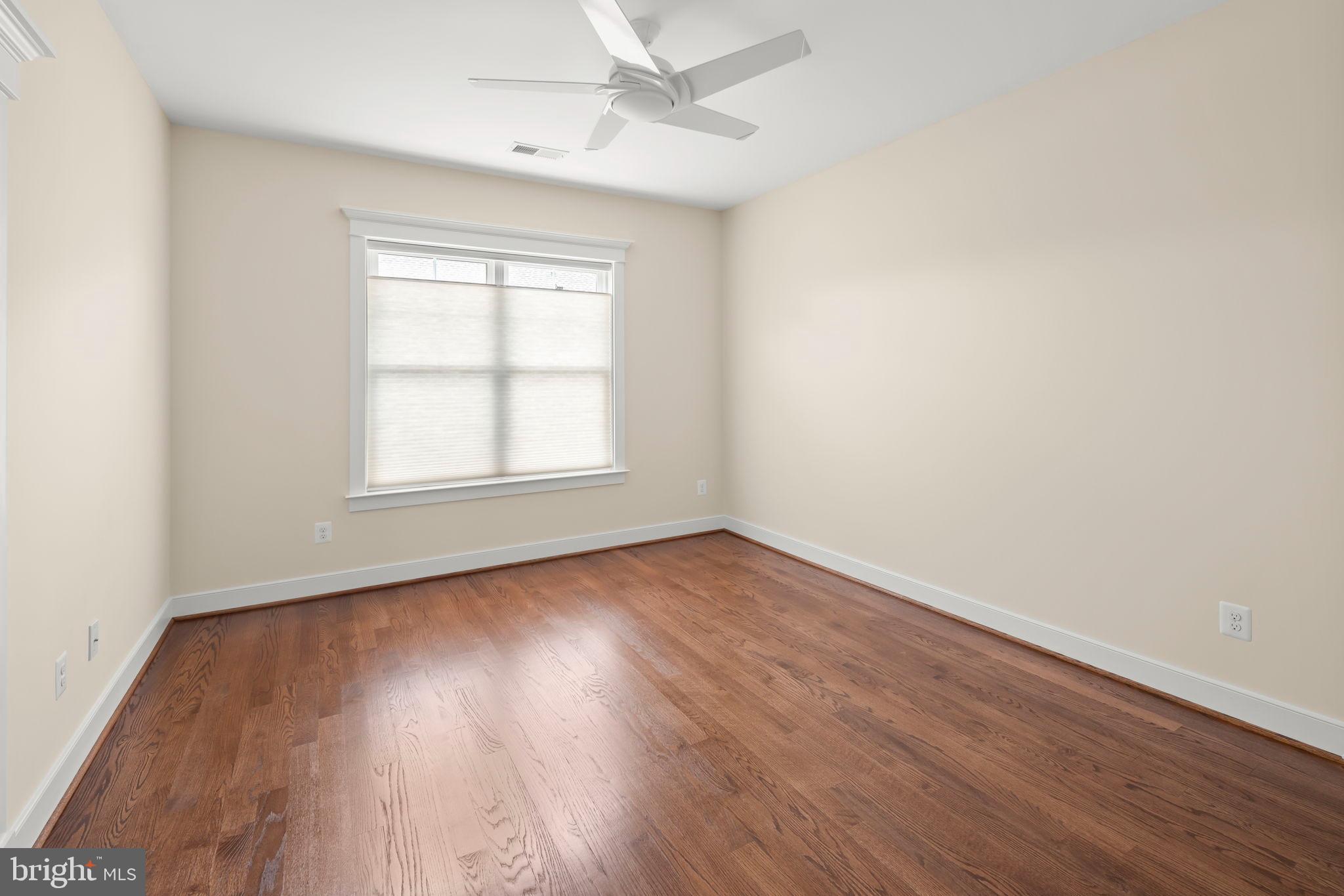 217 Pleasant Street Southwest Vienna, VA 22180 - Photo 60 of 80 an empty room with wooden floor ceiling fan and windows