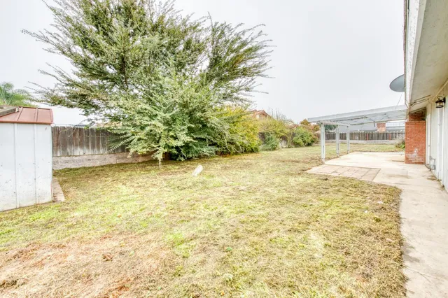 a view of swimming pool with lawn chairs and wooden fence