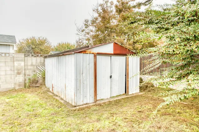 a view of backyard of house with wooden fence