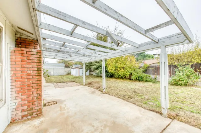 a view of a patio with a table and chairs and floor to ceiling window