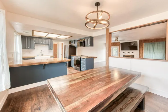 a kitchen with stainless steel appliances kitchen island granite countertop a stove and cabinets
