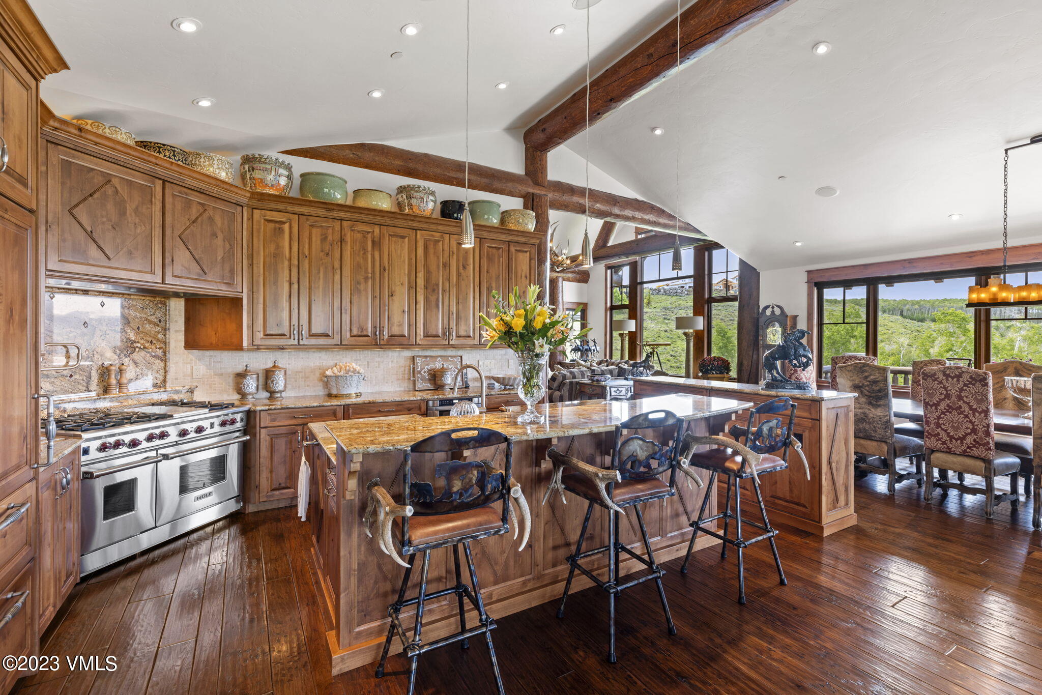 940 Summit Trail Edwards, CO 81632 - Photo 11 of 64 a kitchen with stainless steel appliances granite countertop a stove top oven a dining table and chairs with wooden floor