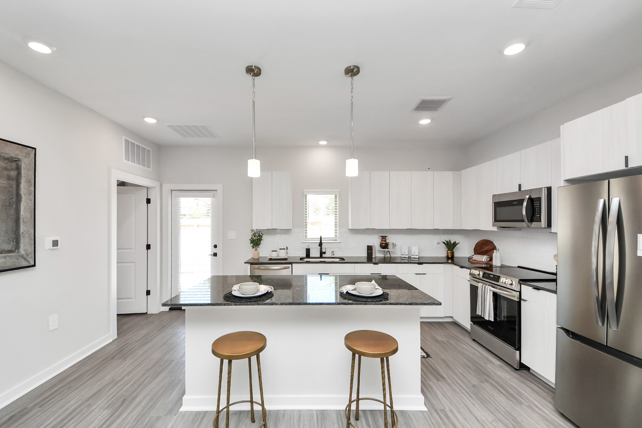 7711 Longmire Road, Unit 2 Conroe, TX 77304 - Photo 34 of 48 Boasting luxury finishes-stylish Island kitchen,granite counters,subway tile backsplash,ample custom cabinet space,stainless appliances,refrigerator,full size washer&dryer included,wood-like flooring throughout,open concept floor plan.