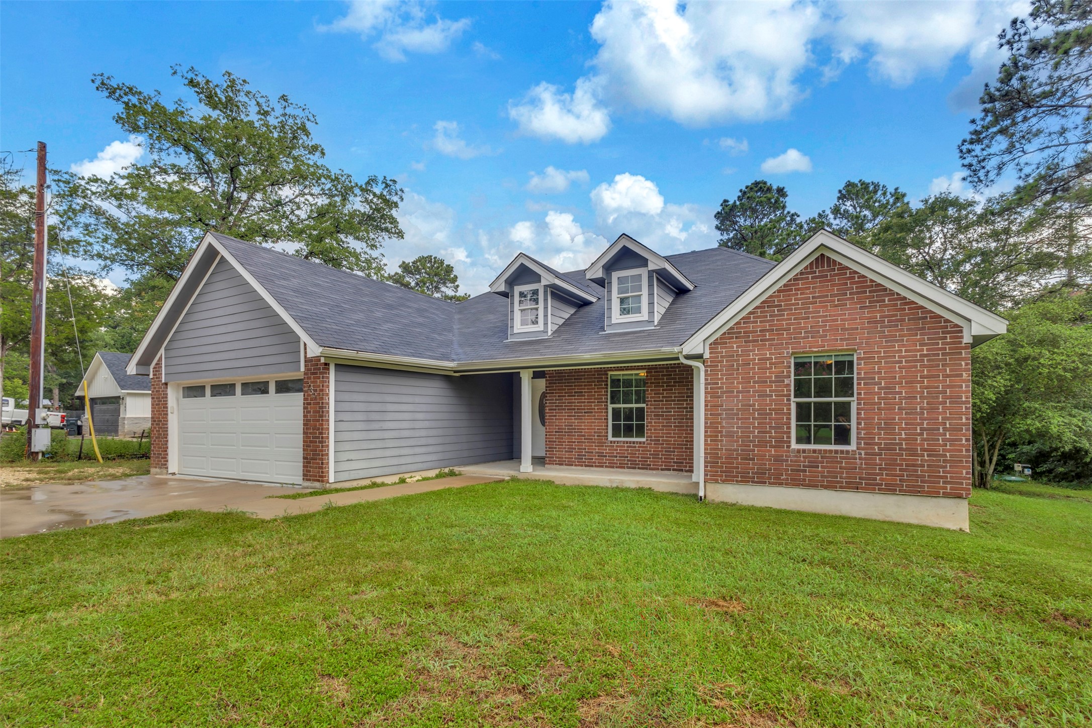 239 Old Firetower Road Bastrop, TX 78602 - Photo 2 of 39 A well-maintained facade features a practical garage and charming dormer windows.