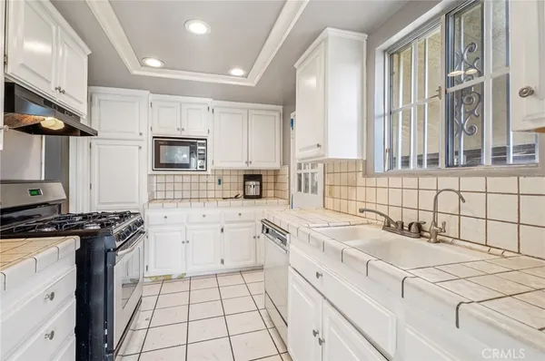 a kitchen with a sink stove top oven and cabinets