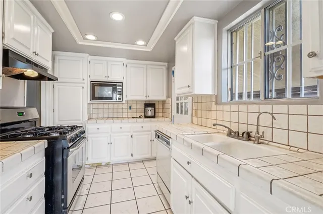 a kitchen with a sink stove top oven and cabinets